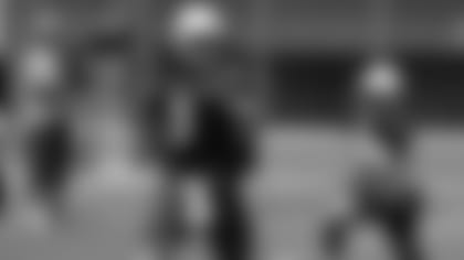 QB Josh Rosen se deshace del balón mientras es presionado durante el mini-campamento del martes