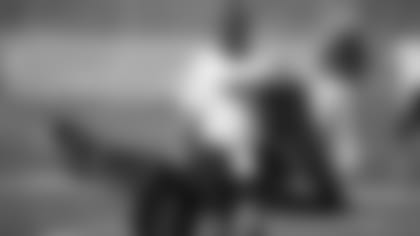 Mike Davidson walks off the field carrying the field markers during a 2010 practice.