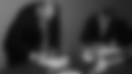 Andy Reid signs his contract with the Chiefs.