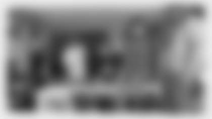 In this still image from video provided by the NFL, Chase Young, right, talks on a cell phone during the NFL football draft Thursday, April 23, 2020, in Washington. Young was chosen by the Washington Redskins. (NFL via AP)