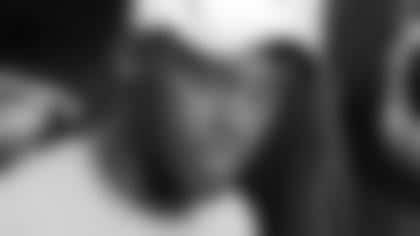 McGinest signs memorabilia.