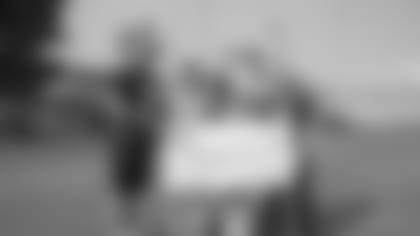 (77) Andrew Whitworth of the Los Angeles Rams poses with a check to the Tragedy Assistance Program for Survivors families with Honda after a walk through , Saturday, November 10, 2018, in Los Angeles, CA. (Jeff Lewis/Rams)