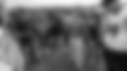 HC John Harbaugh speaks to players in a huddle.