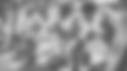 OLB Jaylon Ferguson kneels with teammates on sideline.