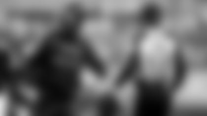 Baltimore Ravens head coach John Harbaugh speaks with a referee during a game.