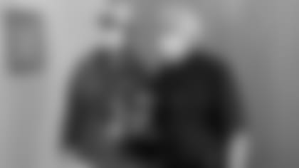 Head coach John Harbaugh and Father Christopher J. Whatley