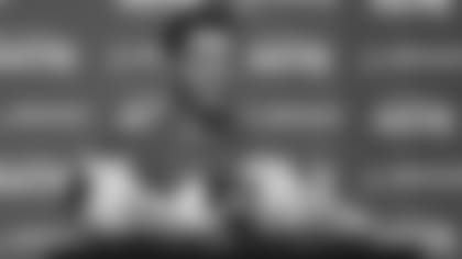 Seattle Seahawks quarterback Russell Wilson talks to reporters Thursday, Dec. 2, 2021, as his cleats from the NFL's "My Cause My Cleats" charity initiative rest on the podium, before NFL football practice in Renton, Wash. (AP Photo/Ted S. Warren)