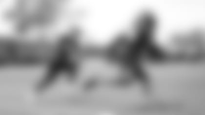 Amanda Ruller, one of three recipients of the NFL's Bill Walsh Diversity Coaching Fellowship is working with the running backs and chases down Darwin Thompson during a drill.