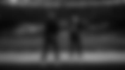 Head coach Pete Carroll and quarterback Geno Smith stand for the playing of the national anthem.