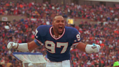 Buffalo Bills linebacker Cornelius Bennett celebrates from atop