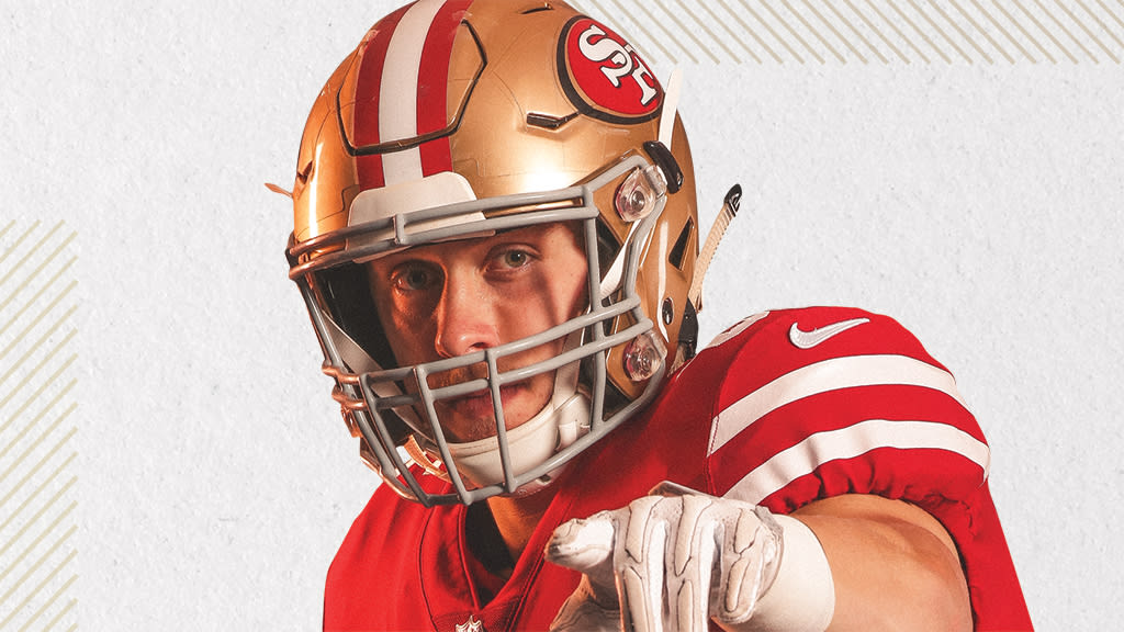 A 49ers fan with a luchador mask on holds a hat before Super Bowl