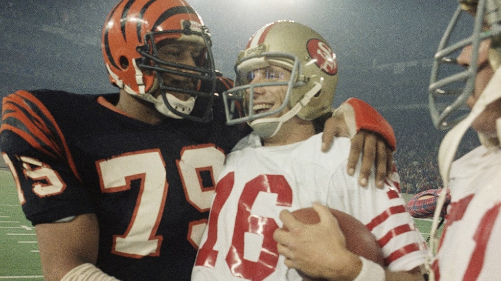 Cinn Bengals defensive player Ross Browner (?79), congratulates San  Francisco 49ers quarterback Joe Montana, right, as he carries the game ball  off the field following the 49ers 26-21 Super Bowl XVI win