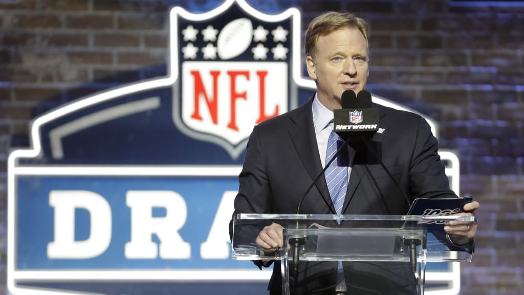 Miami edge rusher Gregory Rousseau, right, holds a team jersey with NFL  Commissioner Roger Goodell after the Buffalo Bills selected Rousseau with  the 30th pick in the first round of the NFL