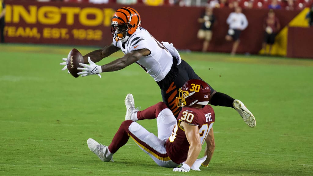 Cincinnati Bengals linebacker Logan Wilson (55) and cornerback Mike Hilton  (21) bring down Buffalo Bills quarterback Josh Allen (17) during the fourth  quarter of an NFL division round football game, Sunday, Jan.