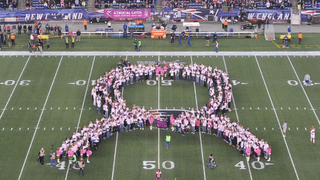 Fans wearing Crucial Catch t-shirts hold a large American flag for the  national anthem before an NFL football game between the Los Angeles Rams  and the New York Giants, Sunday, Oct. 17