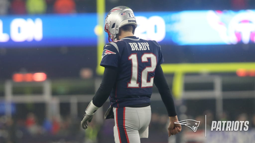 New England Patriots Tom Brady walks off of the field carrying his