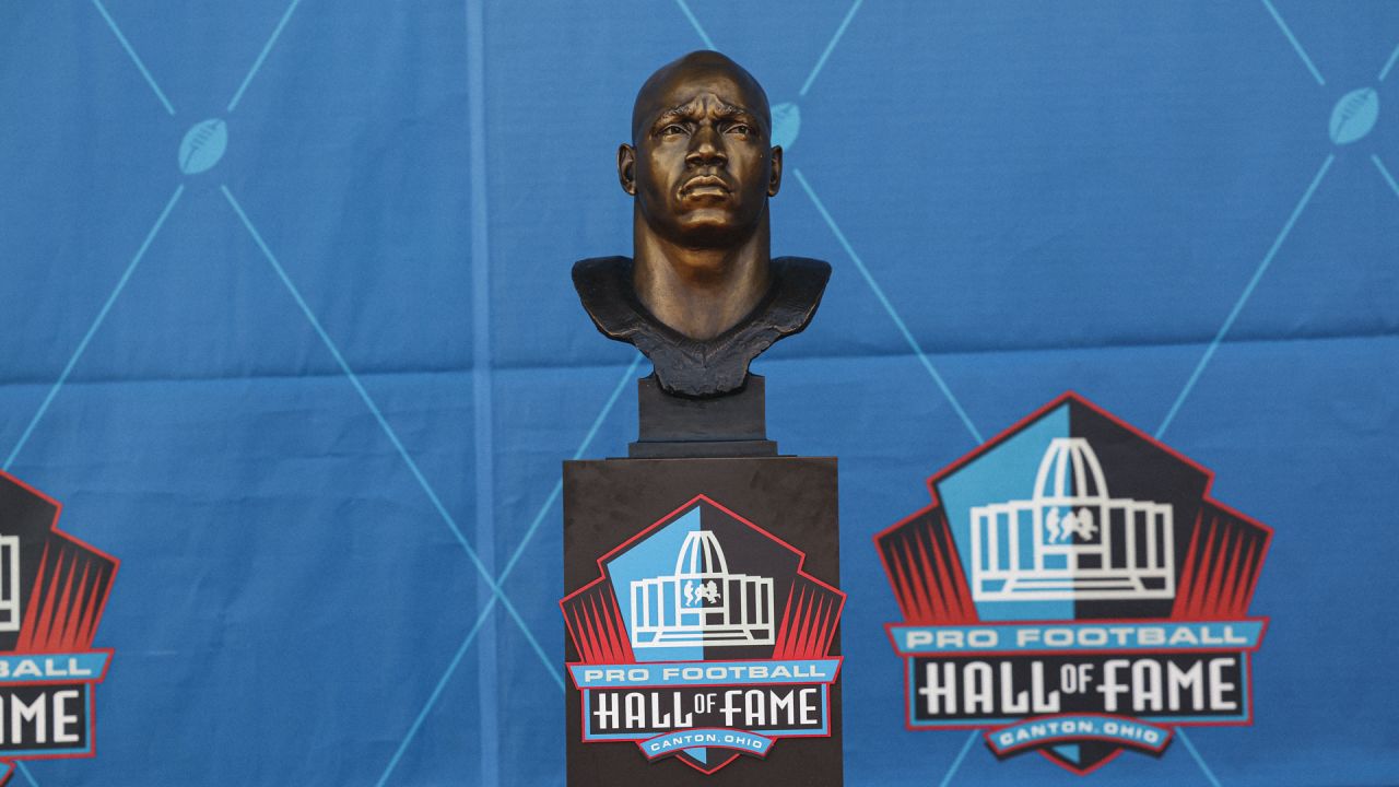 Former NFL player Bryant Young, right, poses with his bust and presenter  Edward DeBartolo Jr., during an induction ceremony at the Pro Football Hall  of Fame in Canton, Ohio, Saturday, Aug. 6