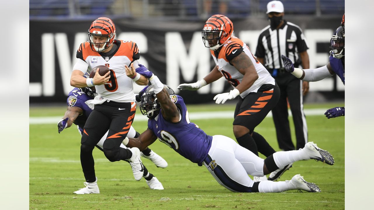 Cincinnati Bengals quarterback Joe Burrow (9) carries the ball against  Baltimore Ravens linebacker Patrick Queen (6) during the first half of an  NFL wild-card football game Sunday, Jan. 15, 2023, in Cincinnati. (