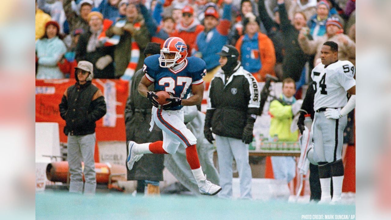 Buffalo Bills, from Left, Bill Brooks, Andre Reed, Mickey Washington, Bruce  Smith (looking away), Pete Metzelaars (standing), Carwell Gardner, and Nate  Odomes (reaching) celebrate in their Locker room with the Lamar Hunt