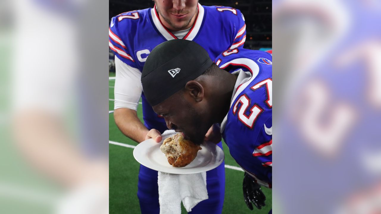 Josh Allen of the Buffalo Bills eats a turkey leg while he walks off