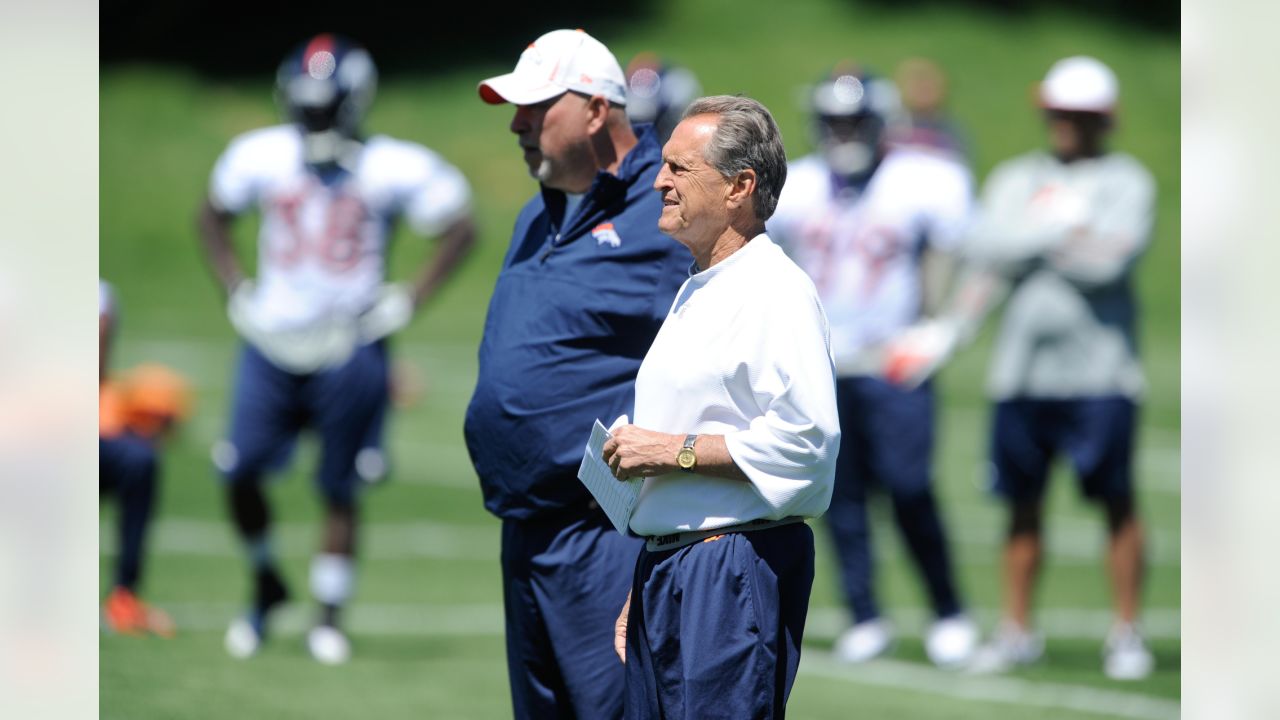 FILE - Denver Broncos offensive line consultant Alex Gibbs, back, looks on  as linemen take part in drills after the morning session at the team's NFL  training camp in Englewood, Colo., in