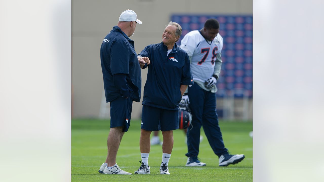 FILE - Denver Broncos offensive line consultant Alex Gibbs, back, looks on  as linemen take part in drills after the morning session at the team's NFL  training camp in Englewood, Colo., in