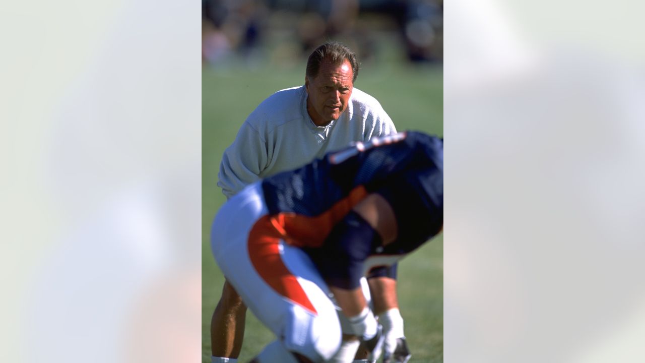 FILE - Denver Broncos offensive line consultant Alex Gibbs, back, looks on  as linemen take part in drills after the morning session at the team's NFL  training camp in Englewood, Colo., in