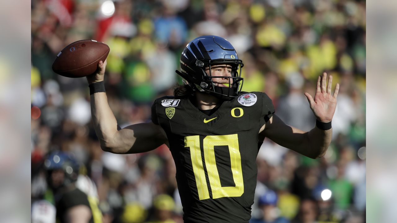 Justin Herbert Oregon Ducks Unsigned Green Jersey Throwing Photograph