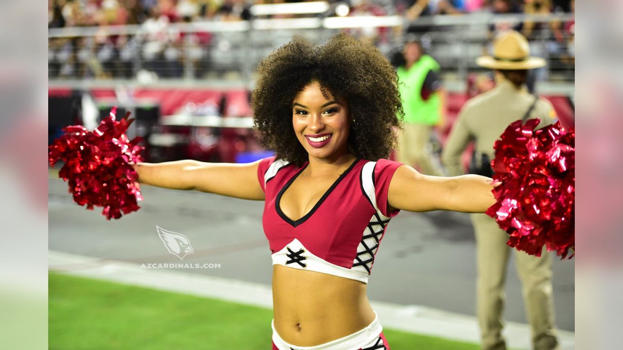 An Arizona Cardinals' cheerleader performs a high kick during the