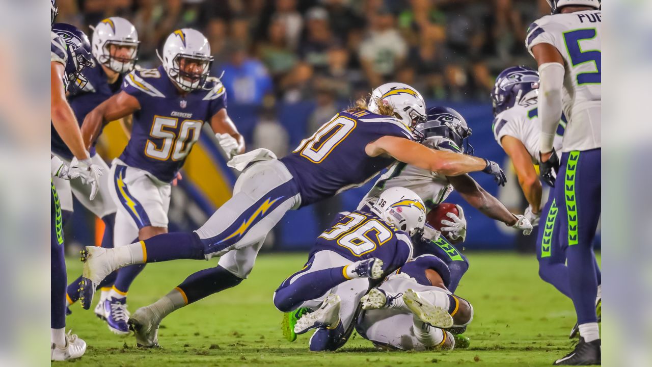 Seattle Seahawks wide receiver Jaron Brown (18) is stopped by Los Angeles  Chargers defensive back Brandon Facyson (28) after a catch during the first  half of an NFL preseason football game in