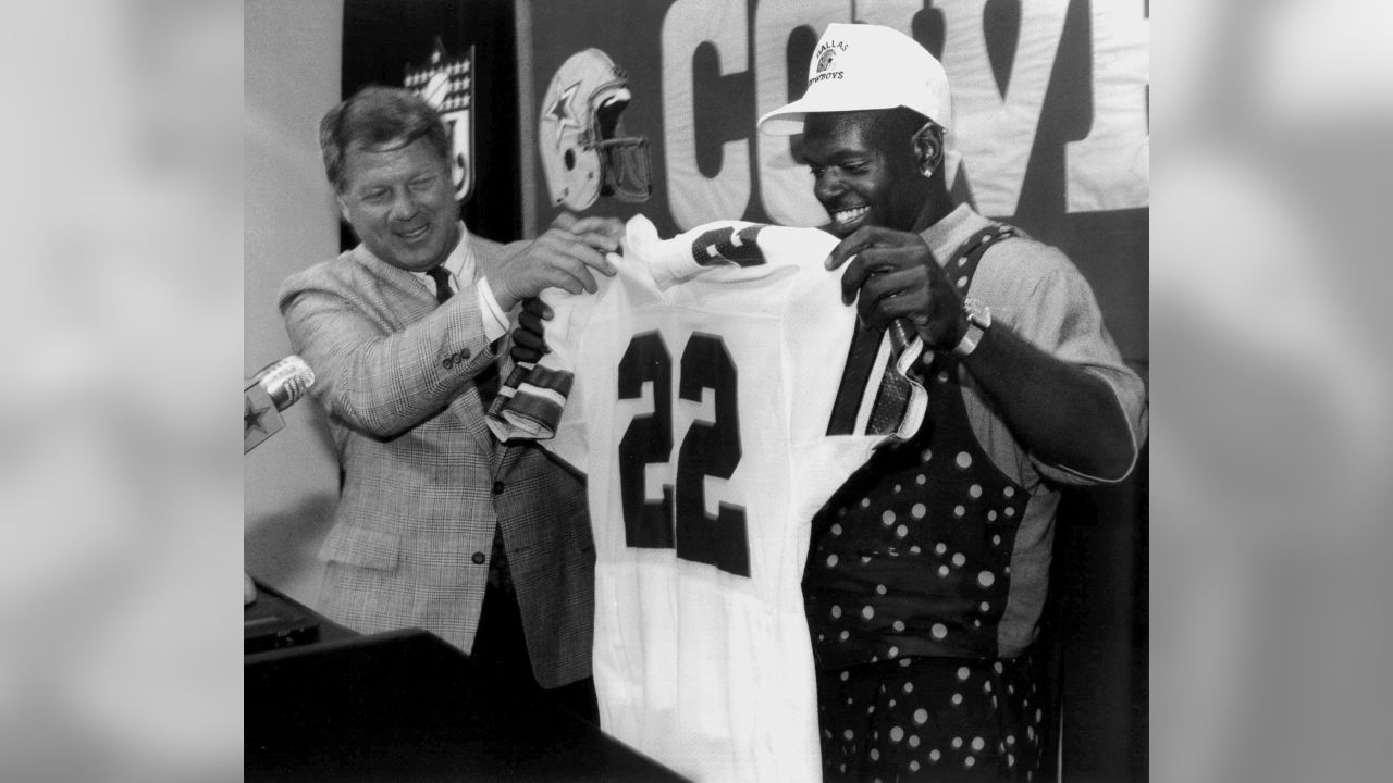 Former Dallas Cowboys head coach Jimmy Johnson, left, hands Florida running  back Emmitt Smith his No. 22 jersey as the Cowboys 1990 No. 1 draft pick is  introduced at the Cowboys training