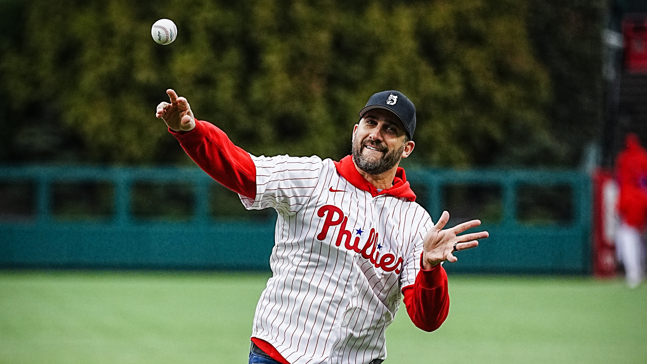 Philadelphia Phillies - Nick Sirianni throwing the first pitch before the  game at Citizens Bank Park. He's got a smile on his face. He's wearing a  red pinstripes Phillies jersey, a red