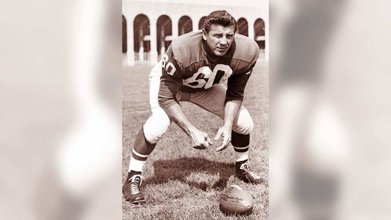 Philadelphia Eagles' Chuck Bednarik looks at an Associated Press photo of  Frank Gifford holding an ice pack to his head in his hospital bed, Nov. 22,  1960 in Philadelphia. Bednarik said he