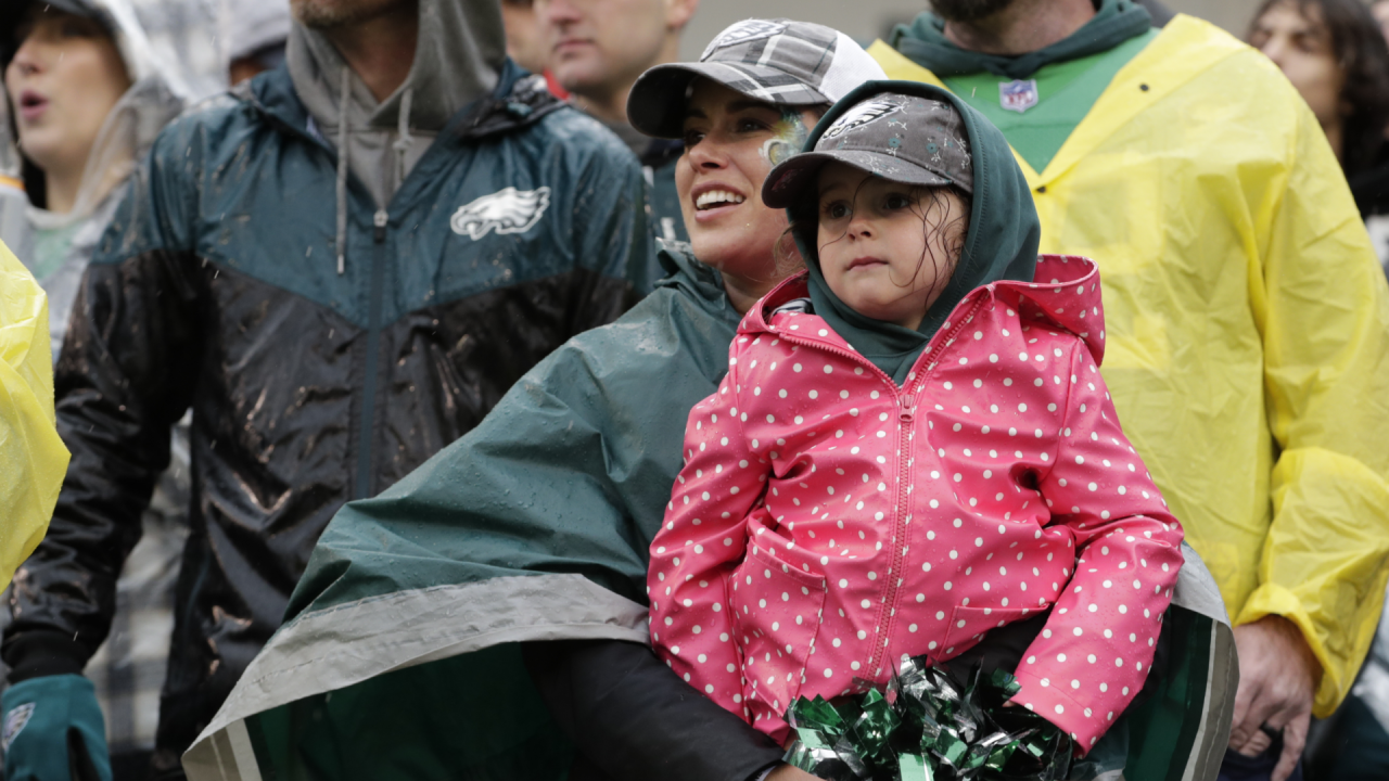 Fans wearing ponchos sit in the rain and watch the New York Jets