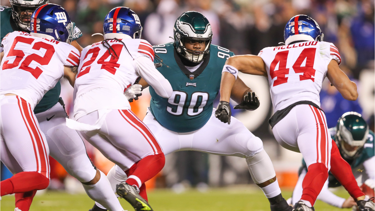 PHILADELPHIA, USA, JANUARY 18, 2023: New York Giants vs. Philadelphia Eagles.  NFL Divisional Round 2023, Silhouette of two NFL American Football Players  against each other. Big screen in background Stock Photo