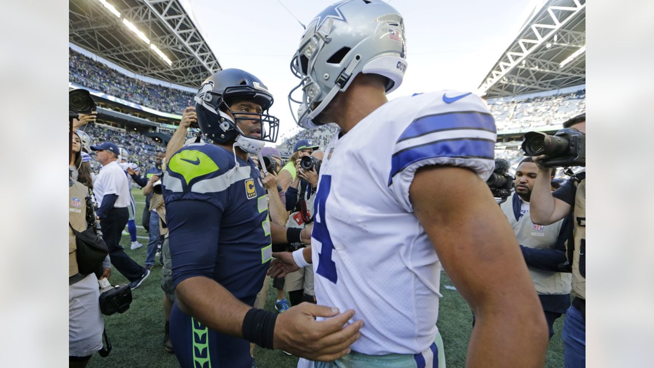 Seattle Seahawks quarterback Russell Wilson, right greets a former  teammates, Oakland Raiders t …