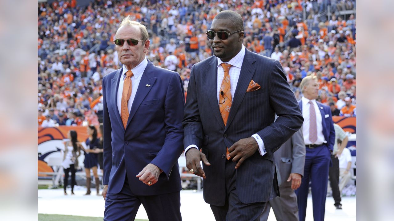 Former Denver Broncos center Tom Nalen hugs his wife during a ceremony  where Nalen was inducted into the Denver Broncos Ring of Fame at an NFL  football game between the Denver Broncos