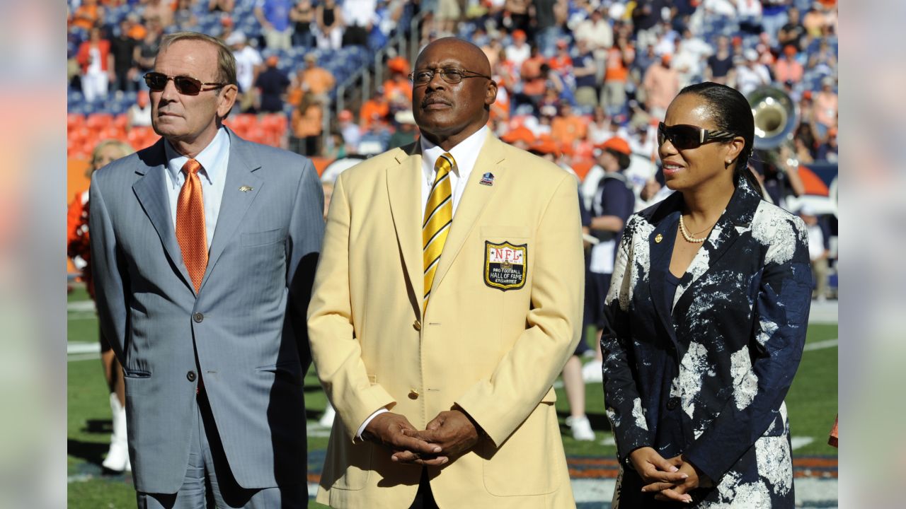 Former Denver Broncos center Tom Nalen hugs his wife during a ceremony  where Nalen was inducted into the Denver Broncos Ring of Fame at an NFL  football game between the Denver Broncos