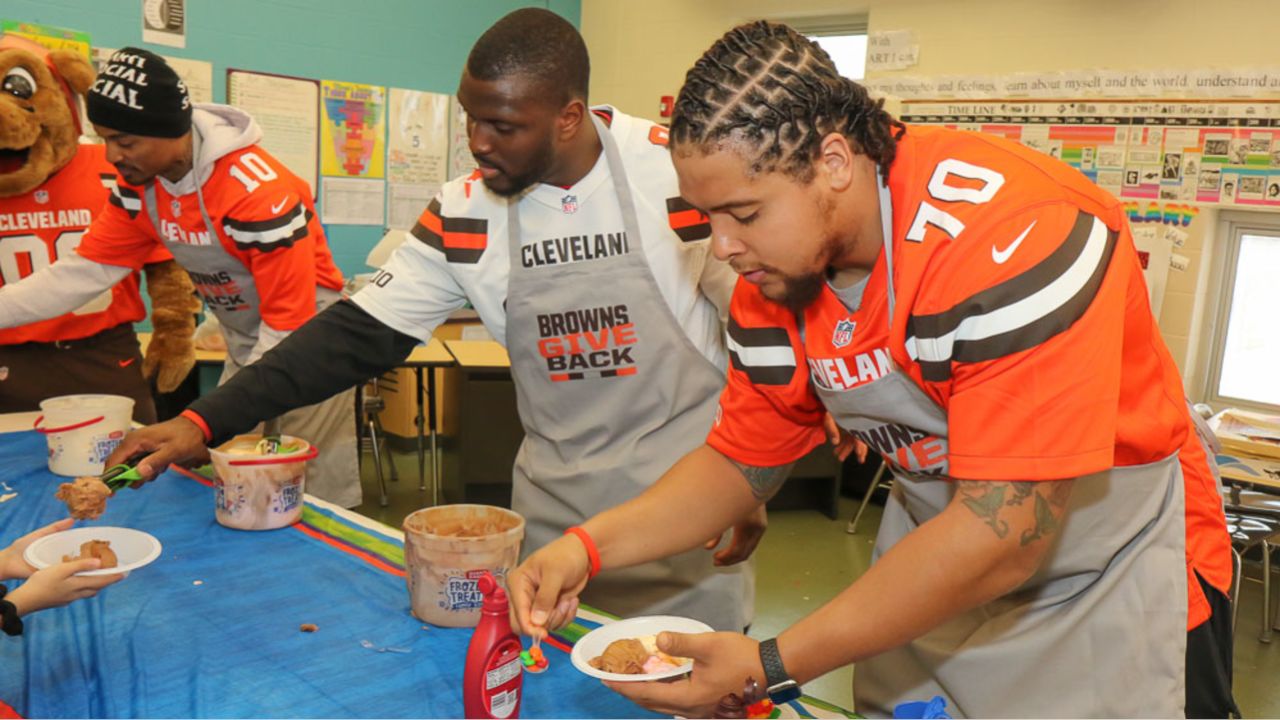 Browns players serve students ice cream at Paul L. Dunbar Elementary School during Tuesday's surprise visit.
