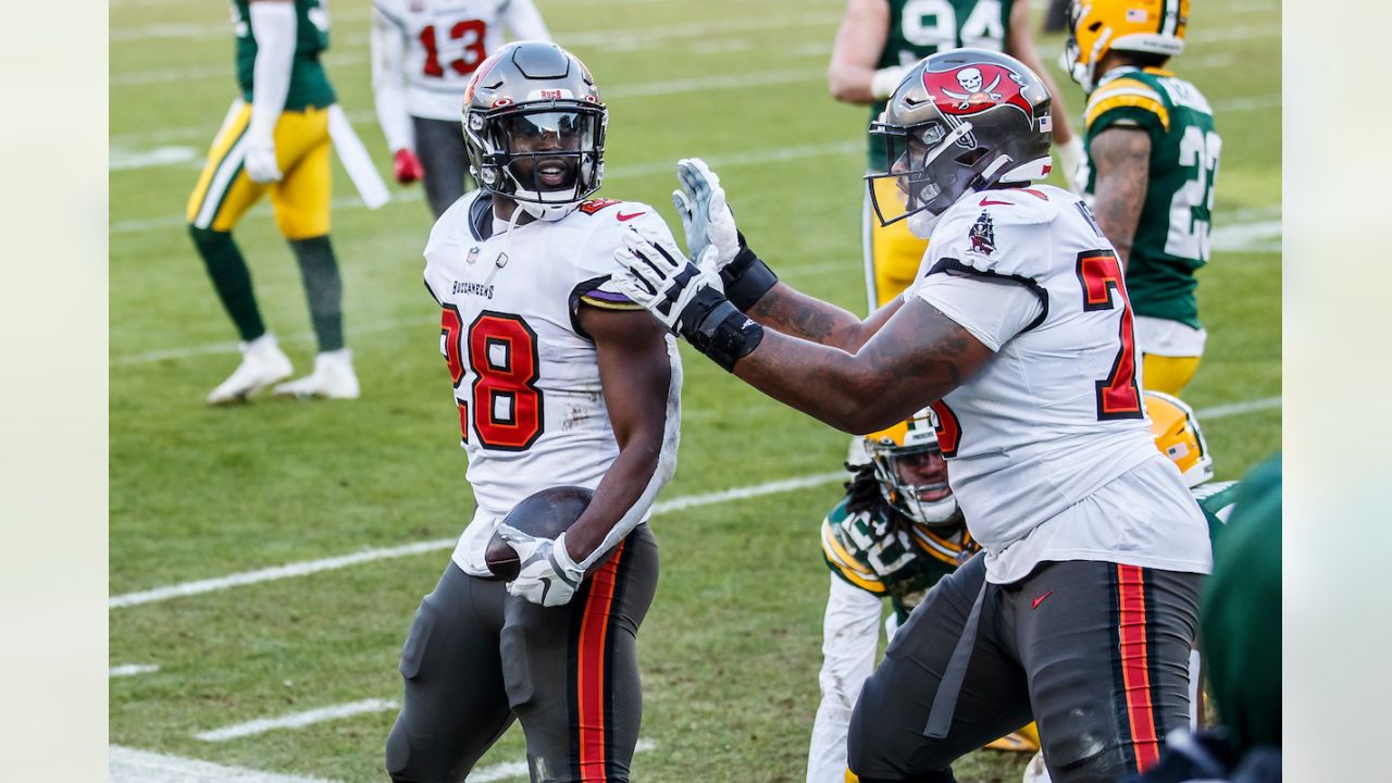 Tampa Bay Buccaneers' Leonard Fournette (28) scores on a 20-yard touchdown  run against the Green Bay Packers during the first half of the NFC  championship NFL football game in Green Bay, Wis.