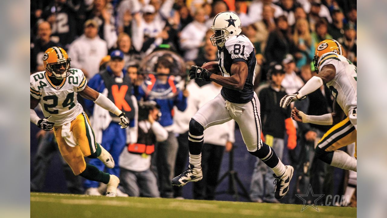 Dallas Cowboys wide receiver Terrell Owens (81) pulls in a 48-yard pass as  Green Bay Packers linebacker A.J. Hawk (50) defends in the second quarter  in their NFL football game in Irving