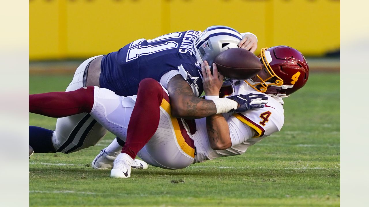 El quarterback Taylor Heinicke (4), del Football Team de Washington, suelta el balón mientras es capturado por el linebacker Micah Parsons (11), de Dallas Cowboys, durante la primera mitad del juego de la NFL, el domingo 12 de diciembre de 2021, en Landover, Maryland. Dallas recuperó el balón y anotó en la jugada. (AP Foto/Alex Brandon)