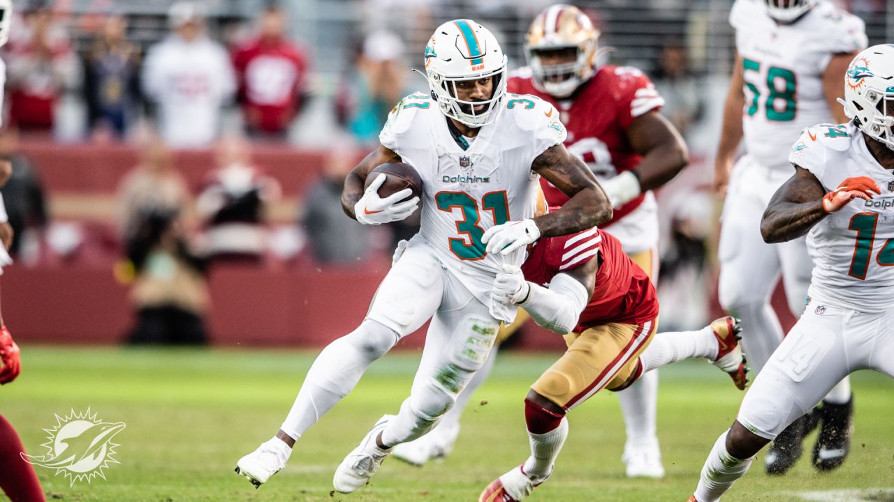 San Francisco 49ers vs. Miami Dolphins. NFL Game. American Football League  match. Silhouette of professional player celebrate touch down. Screen in  background. Stock Photo