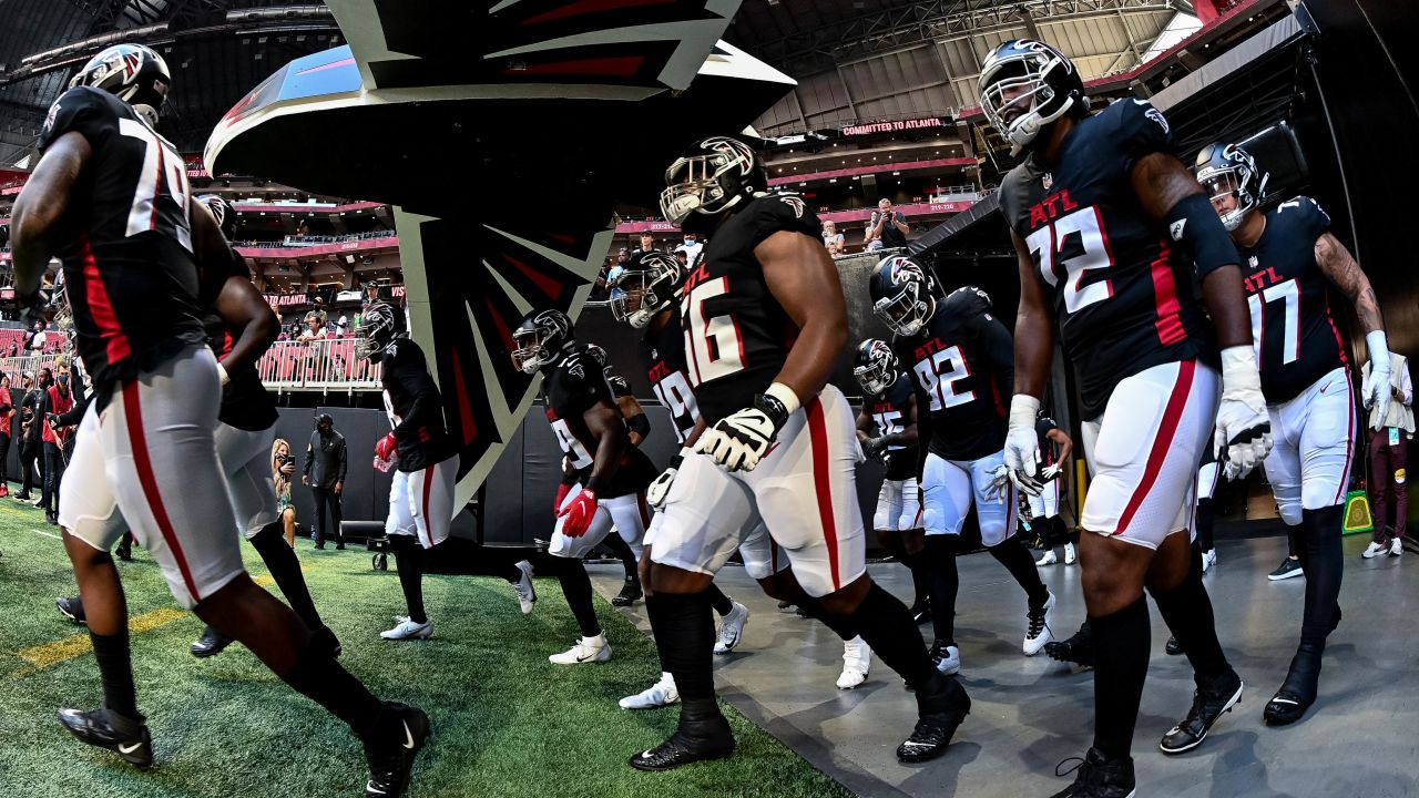 Tennessee Titans offensive guard Chandon Herring (68) fist bumps an Atlanta  police officer after a preseason NFL football game against the Atlanta  Falcons, Friday, Aug. 13, 2021, in Atlanta. The Tennessee Titans