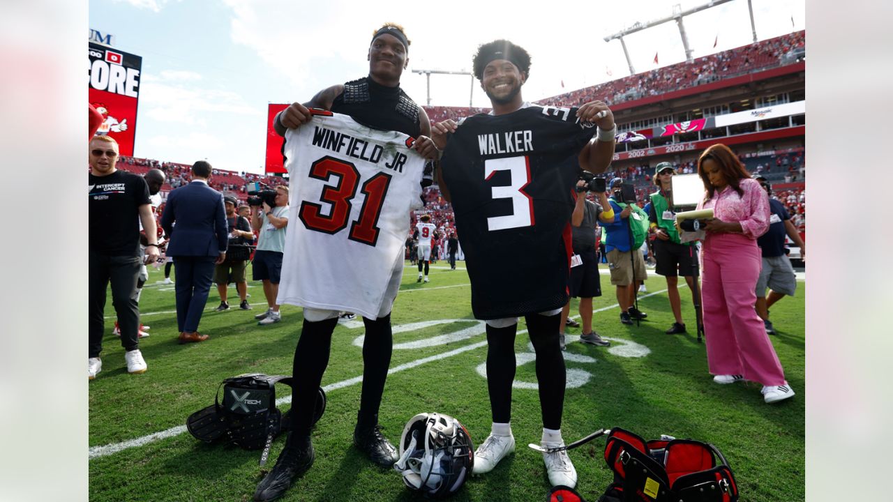 Elisha Jarrett (center), the mother of Atlanta Falcons defensive tackle Grady  Jarrett, gives her son a virtual fist pump outside Mercedes-Benz Stadium as  he arrives to play the Seattle Seahawks in the