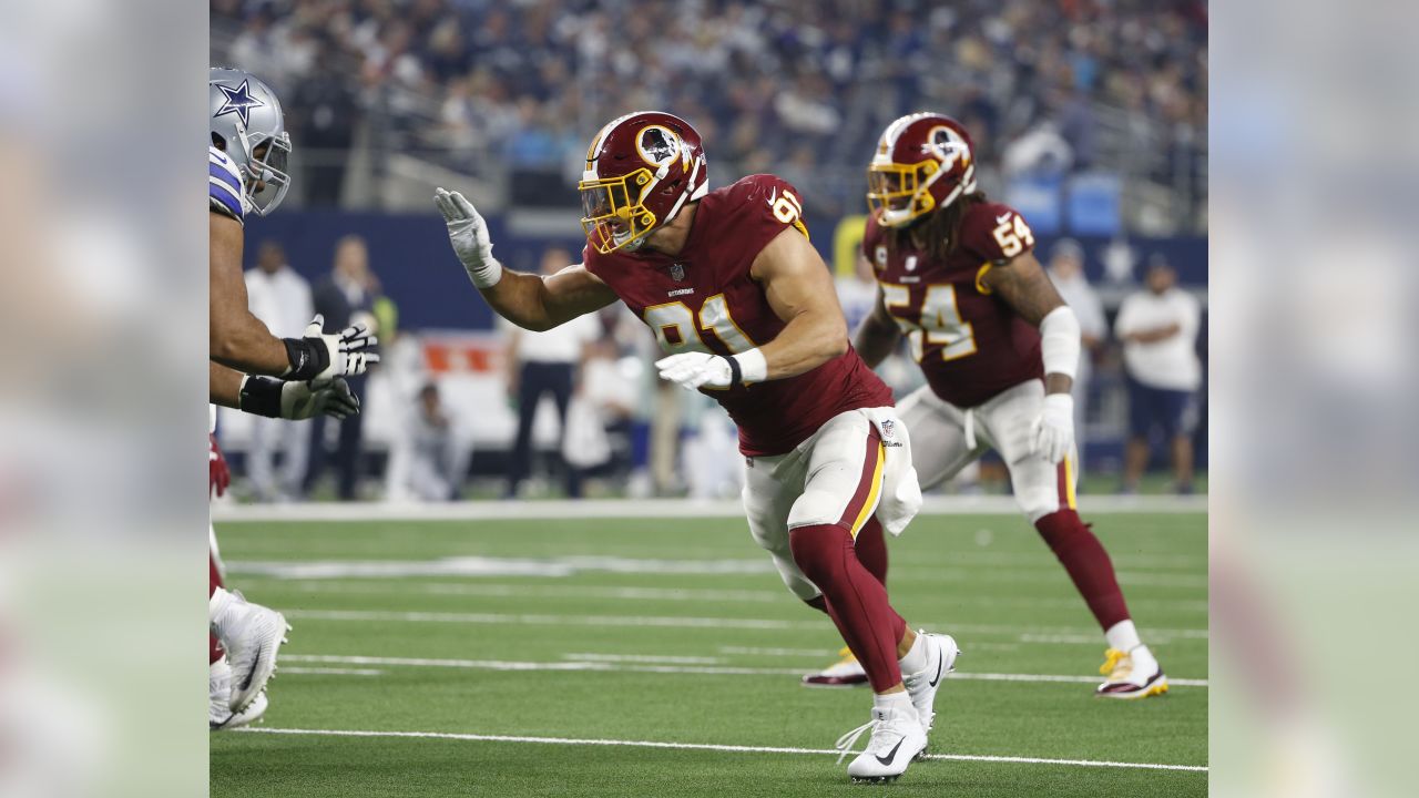 New York Giants running back Saquon Barkley (26) runs past Washington  Redskins outside linebacker Ryan Kerrigan (91) after making a reception in  the first quarter against the Washington Redskins at FedEx Field