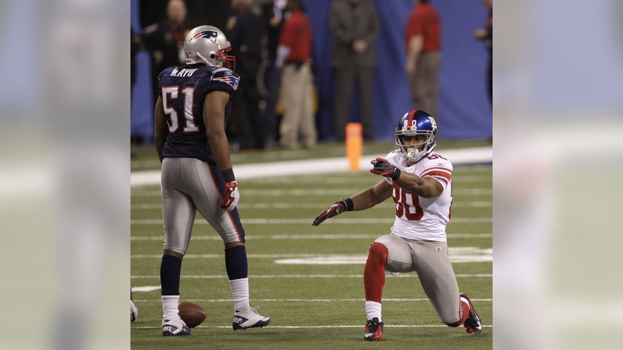 New York Giants wide receiver Victor Cruz (C) catches a two-yard touchdown  pass against New England Patriots safety James Ihedigbo during the first  quarter at Super Bowl XLVI at Lucas Oil Stadium