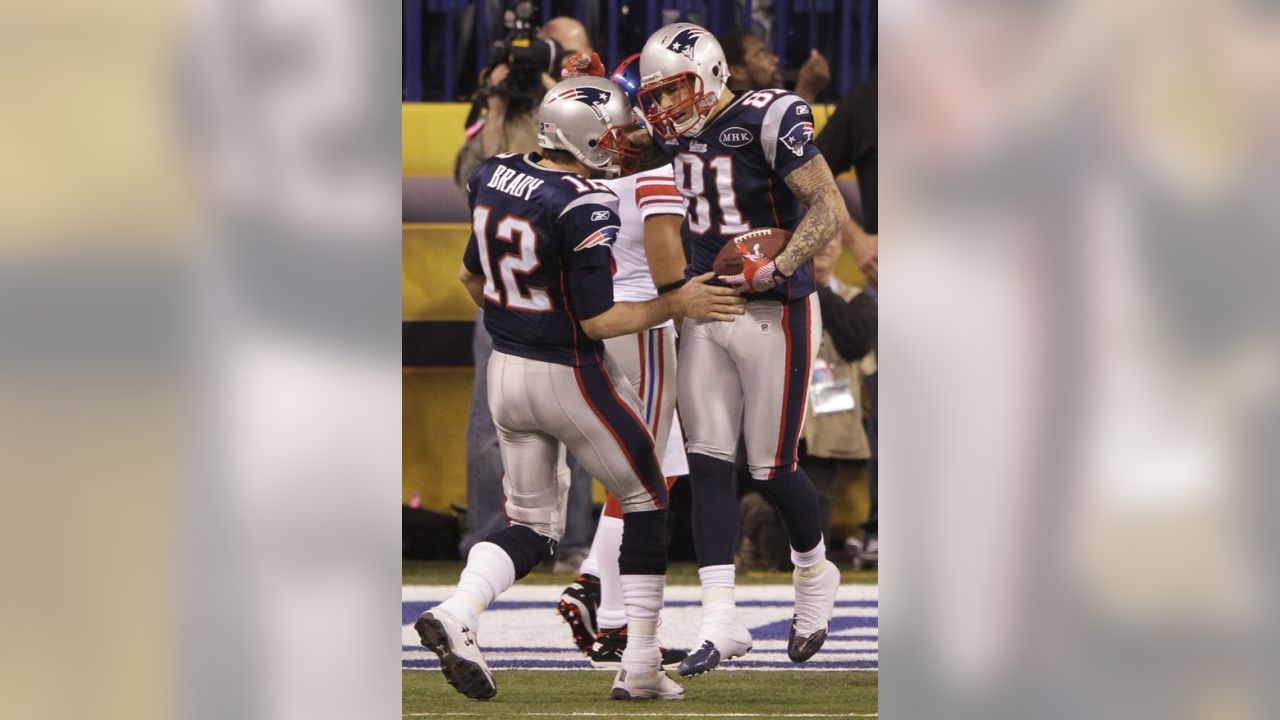 Tight end Aaron Hernandez (81) of the New England Patriots avoids the  tackle of strong safety Deon Grant (34) of the New York Giants to score on  the opening drive of the