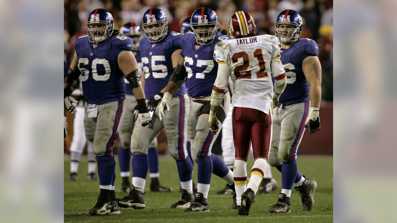 New York Giants running back Saquon Barkley (26) runs past Washington  Redskins outside linebacker Ryan Kerrigan (91) after making a reception in  the first quarter against the Washington Redskins at FedEx Field