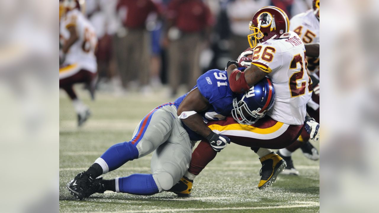 New York Giants Michael Johnson (20) holds up Washington Redskins Clinton  Portis (26) in the first quarter at Giants Stadium in East Rutherford, New  Jersey on September 4, 2008. The Giants defeated